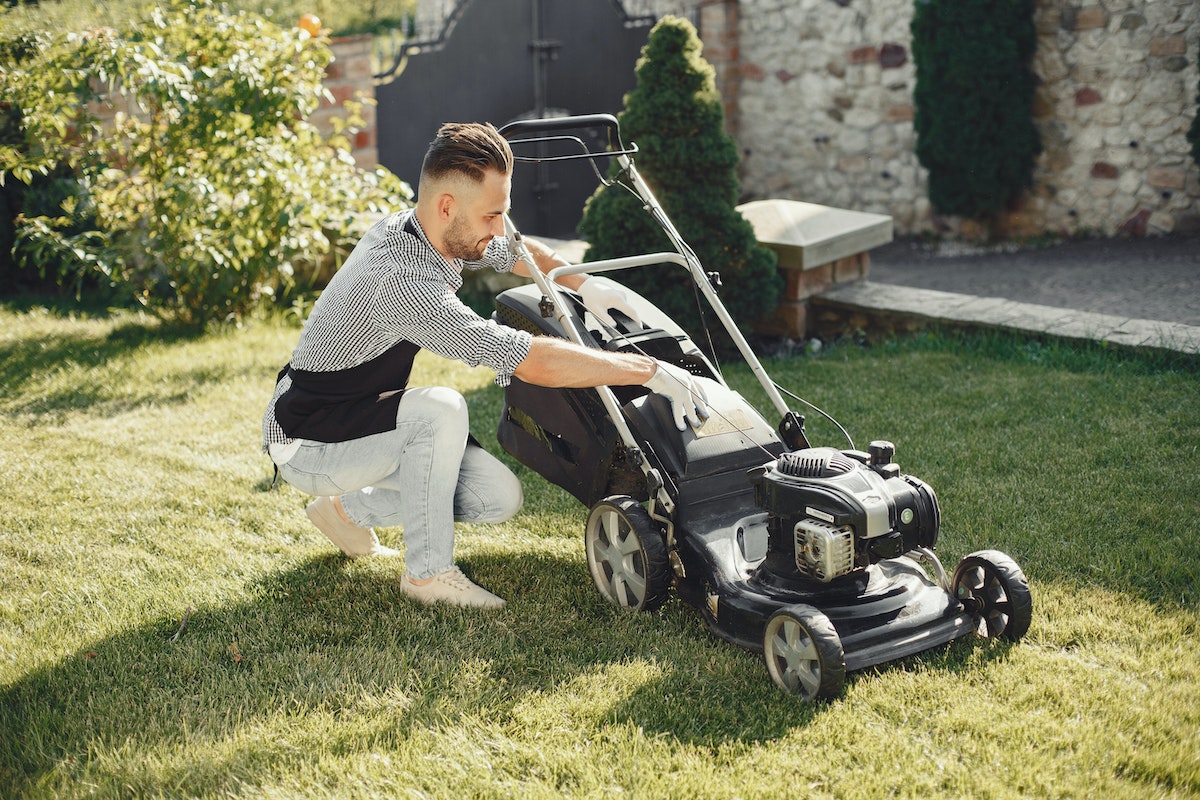 man fixing lawn mower
